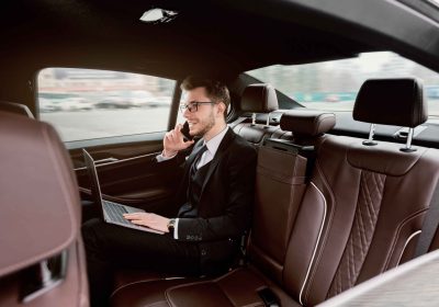 young businessman talking on smart phone in luxury auto